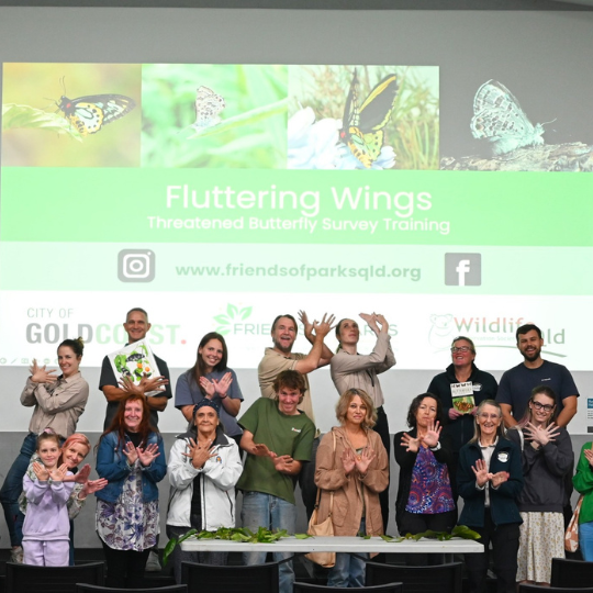 Group photo of participants from the 'Fluttering Wings' threatened butterfly survey training, showcasing a diverse range of individuals smiling and posing with butterfly-related materials.